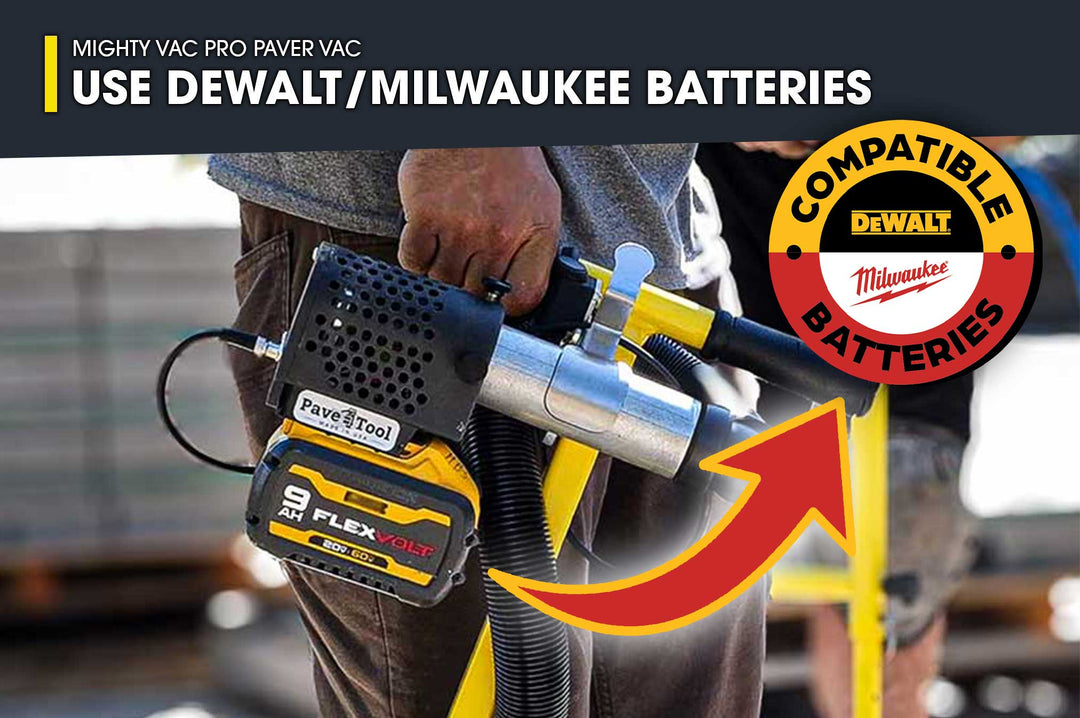 Person holding a paver tool with compatibility for Dewalt and Milwaukee batteries, set against a blurred construction site background.