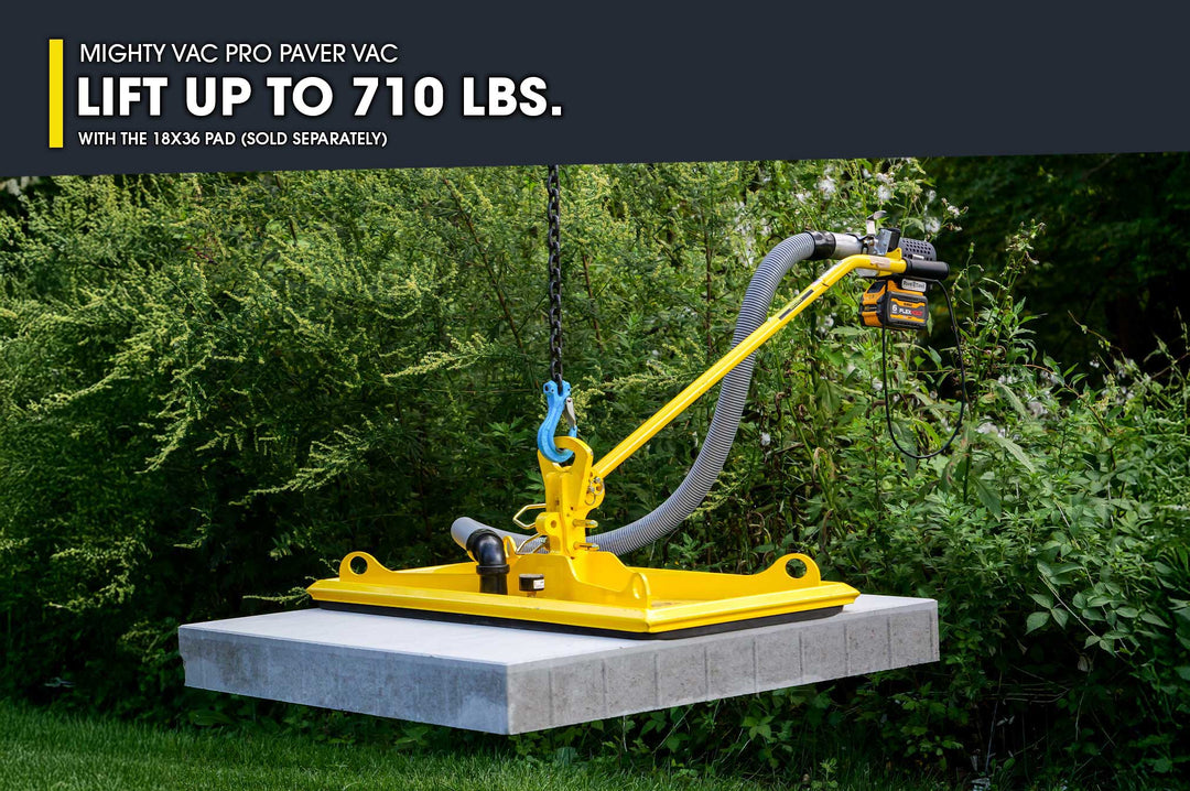 Yellow lifting device on a concrete slab with greenery in the background