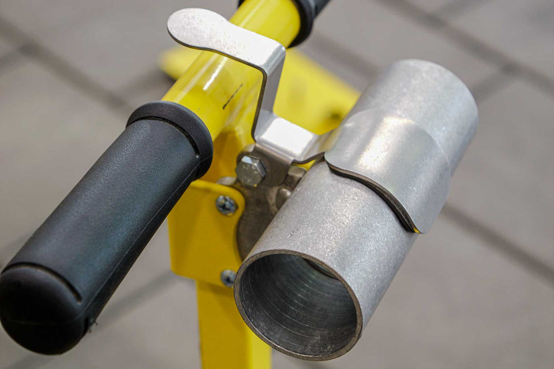 A close-up of a Vac Max Relief Valve attached to a yellow and black plumbing fixture, with a metallic finish on the valve and a rubber handle.